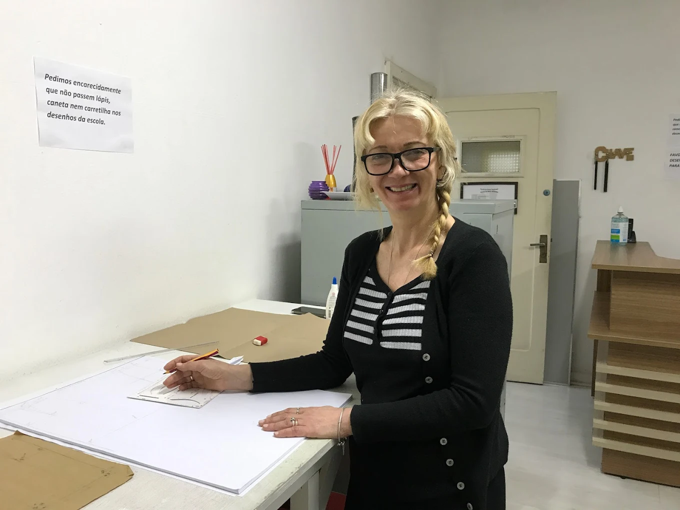 aluna em aula de modelagem e costura com material sobre a mesa