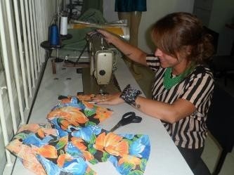 Aluna costurando peça em máquina reta durante aula prática na Escola de Moda Paulistana