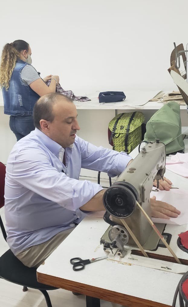 Aluno em aula prática de costura na Escola de Moda Paulistana, confeccionando uma peça durante o curso