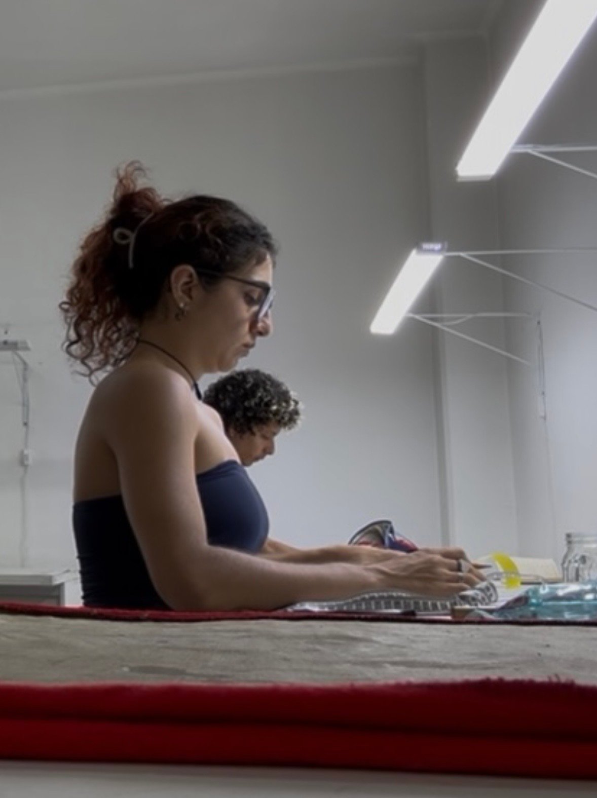 Alunas praticando modelagem e costura durante aula de curso de moda