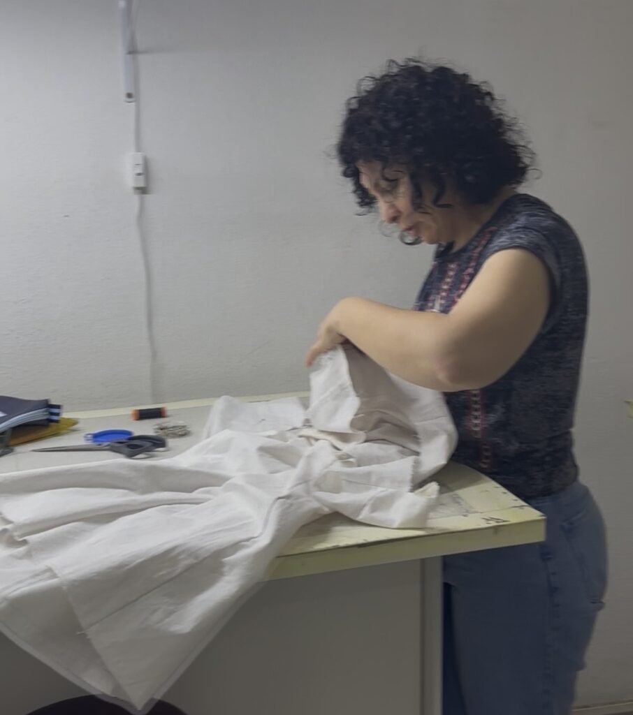 Aluna costurando alinhavo em peça durante aula prática de costura na BERIMOD em São Paulo